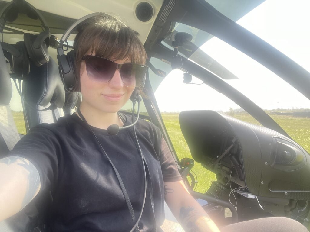 McKenzie in a helicopter wearing a headset during an aerial shoot