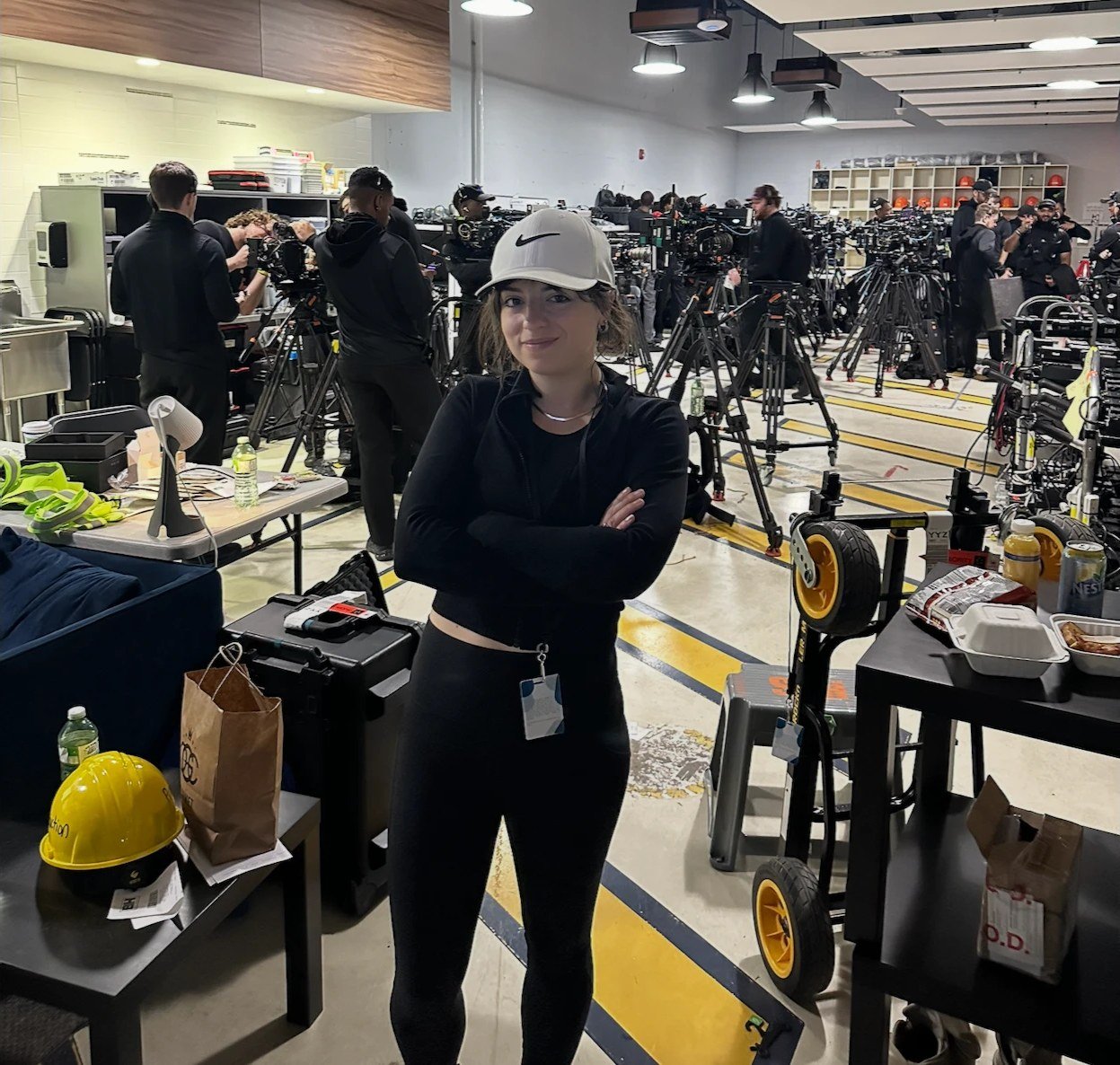 McKenzie on a production floor lined with camera rigs and crew prepping gear